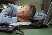 Businessman sleeping on desk in office